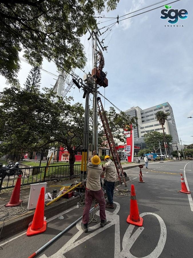 Cuadrilla de SGE ejecutando maniobra en red de media tensión con señalización vial, Envigado